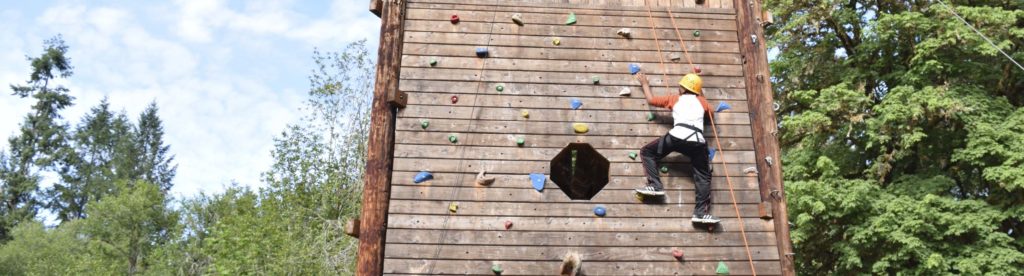 A camper on the climbing tower at Camp Lutherwood Oregon