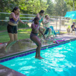 Four middle schoolers jumping in the pool at Camp Lutherwood Oregon