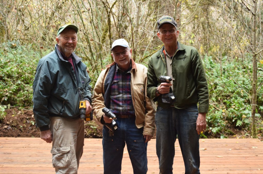 Three men holding drills volunteering for a workday at Camp Lutherwood Oregon