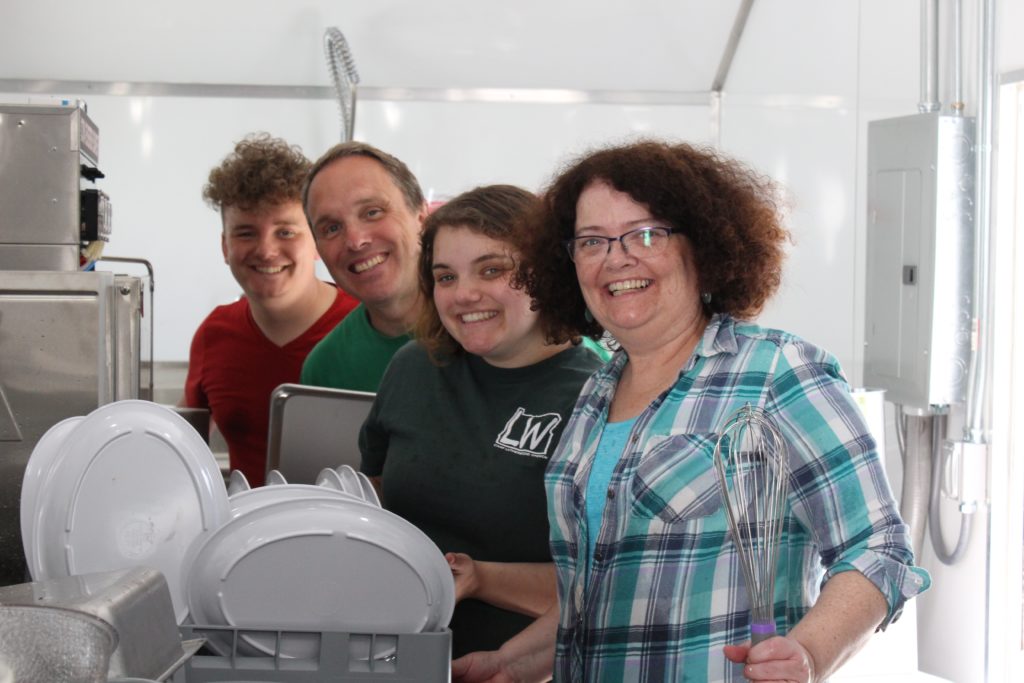 Volunteer adults and high school students washing dishes in the kitchen at Camp Lutherwood Oregon