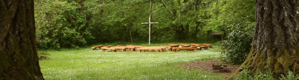 Lower campfire with numerous benches and a large cross at Camp Lutherwood Oregon