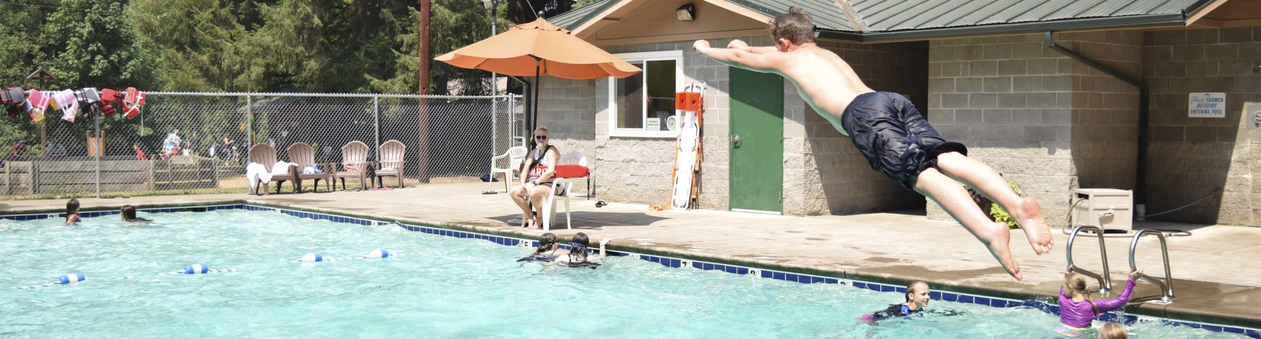 A boy diving in the pool at Camp Lutherwood Oregon