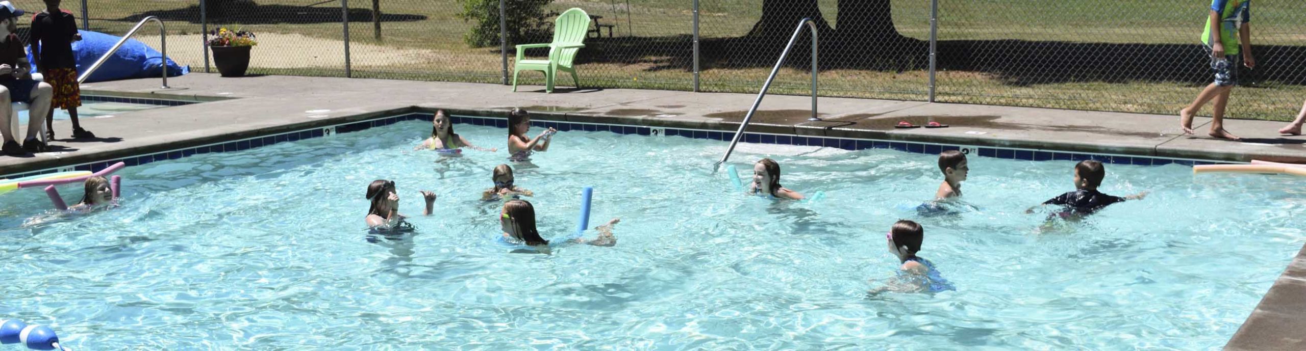 The pool filled with 10 campers swimming with pool noodles at Camp Lutherwood Oregon