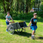 Two boys hauling supplies at work day
