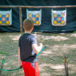 A camper practicing archery